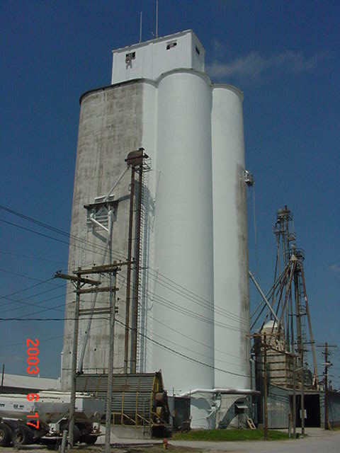 Monroe City, MO: 160 ft. concrete grain elevator being painted during the summer of 2003 at Farmers Elevator & Exchange Company of Monroe City