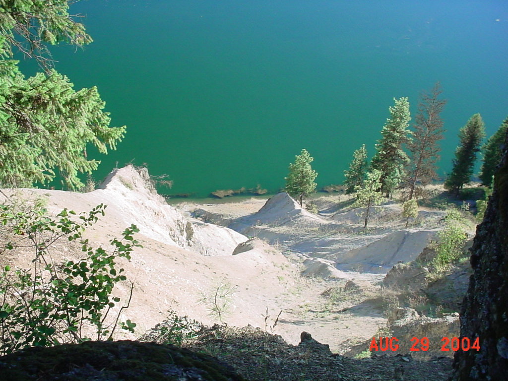 Thompson Falls, MT : Blueside Road is a curving residential and country road that follows the brilliant Clark Fork River. This photo depicts the brilliant contrast of white sandy cliff and brilliant blue of the Clark Fork River.