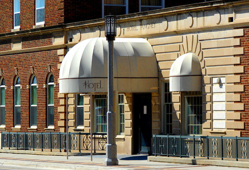 Spencer, IA: The chiseled-in-stone declaration states "Hotel Tangney" while the contemporary awning sports merely: "The Hotel." Regardless of its legal moniker, this multi-story abode locates itself on Spencer's main street, with the entrance shown, serving as its side door. This prestigious establishment also features a gormet restaurant, serving three-course dinners until ten.