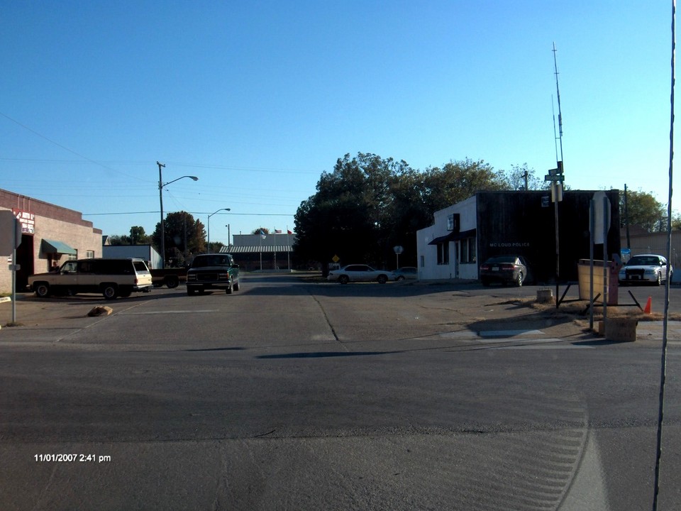 McLoud, OK: View looking south down Main Street, High School in the middle, McLoud Police station on the right.