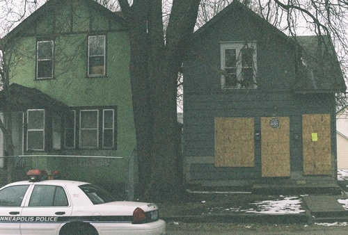 Minneapolis, MN: A Minneapolis police car in front of an abandoned house, Minneapolis' South Side