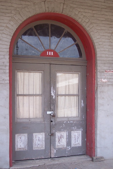 Calvert, TX: Store front window with red brick arch