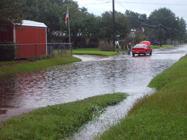Hooks, TX: A resident having pushed their car through a flooded intersection of Rex & Twin Oaks