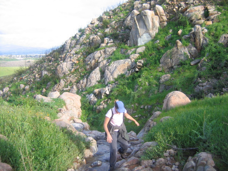 Santee, CA: Hiker crossing small stream in Mission Trails Park (view of west end of Santee on left side of picture).