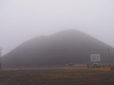 McAdoo, PA: Fog blurs the view of a huge coal mountain on the side of the road.