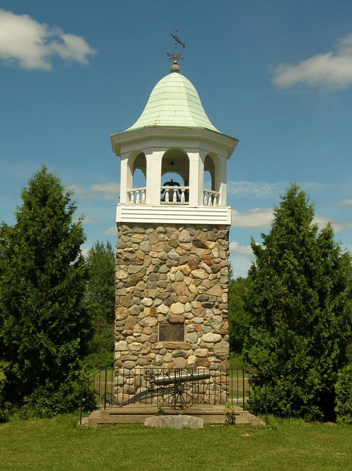 Island Falls, ME: Monument erected in 1978 preserves the high school weather vane and cupola built in 1902. THe high school bell was given by Samuel Campbell in 1903.