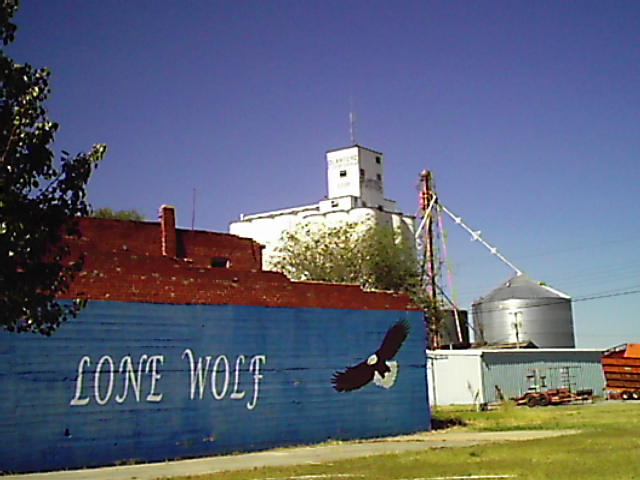 Lone Wolf, OK: Lone Wolf sign of the side of downtown with the COOP in the background