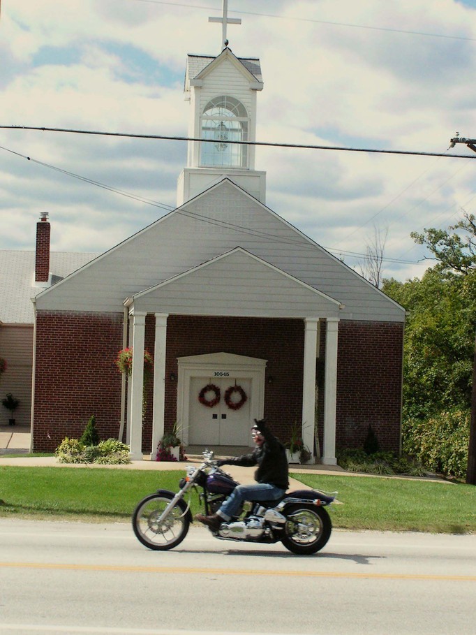 Hillsboro, MO: Motorcylist waving in front of church along Highway 21.