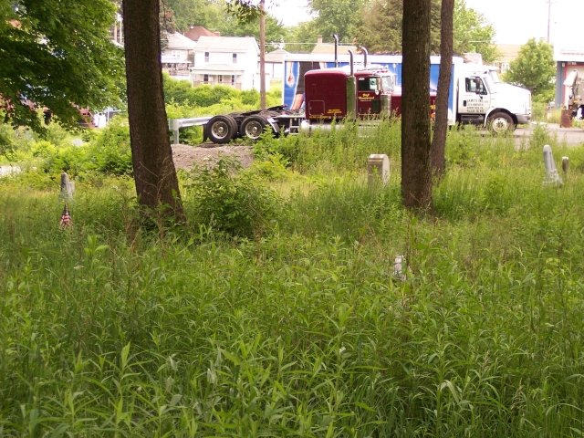 Eau Claire, PA: The overgrown Eau Claire Cemetary leading into a semi-truck lot.