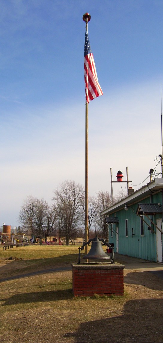 Fort Covington, NY: Fort Covington Fire Station's flag and original Bell that was wrung when we would have a call in the early 1900's