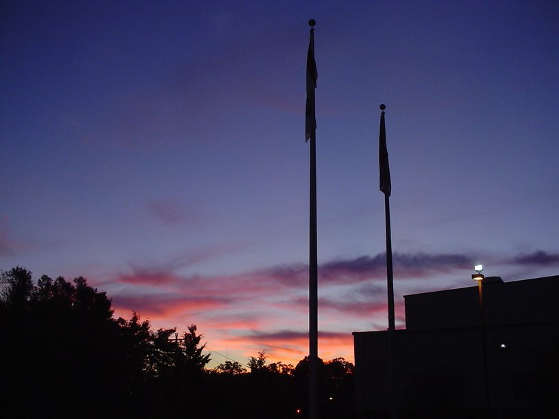 Mooresville, NC: Looking West from Mazeppa Road, USA and NGK Ceramics flags lay still for the ni ght.