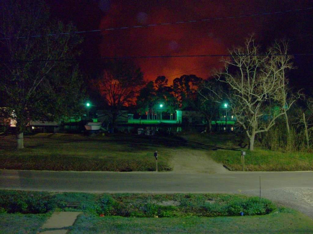 Dulac, LA: A picture of the marshes in the background burning, lighting up the sky with a reddish orange glow.