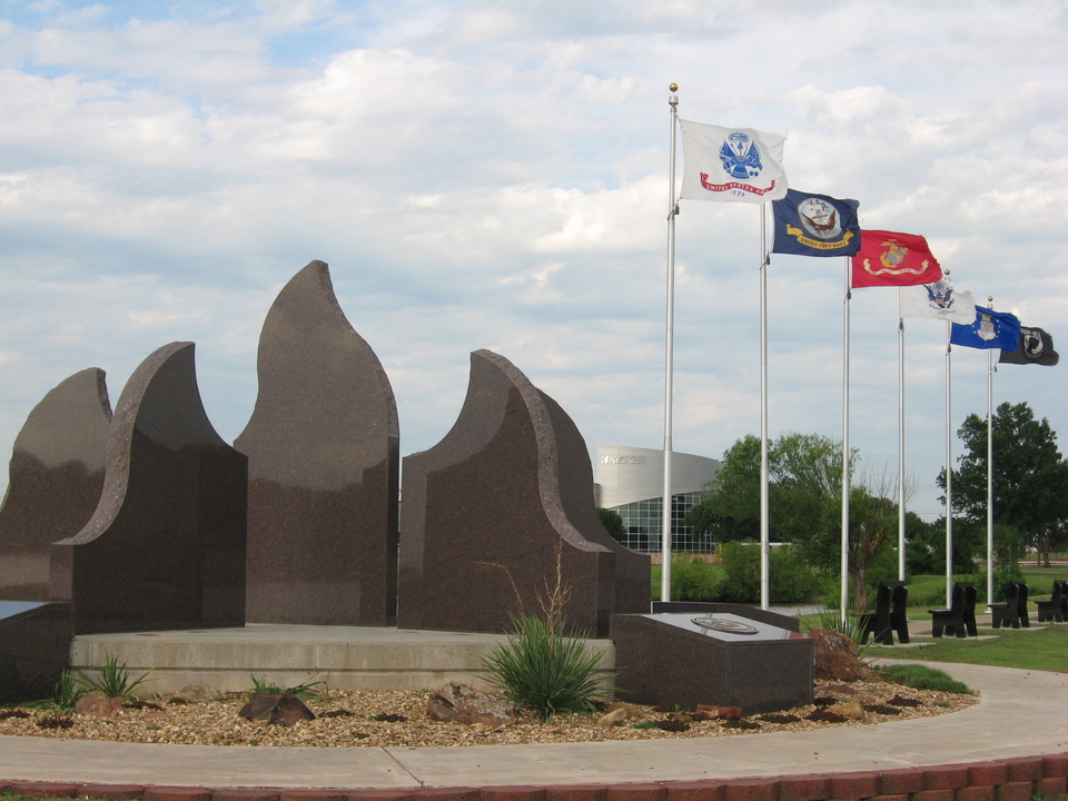 Stillwater, OK: Payne County Veterans' Memorial at Boomer Lake Park. At night red, white and blue spotlights in turn colorfully illuminate the slabs of granite representing Freedom's Flame.