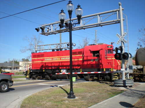 High Springs, FL: This 1956 vintage Electro-Motive diesel (FCEN 47) was seen heading north through High Springs on New Years Eve, 2008, on the Florida Northern Rail Road with empty wagons from Prime Conduit. This approximately 1.75 straight length of track passing through the center of High Springs is all that remains of the Atlantic Coast Line track from Alachua through High Springs and Fort White to Live Oak. Thanks to local businesses who use rail, sights like this are still with us. This stretch of line connects south to Newberry via a switch just north of the Golden Peanut Company. These fragments of the old Alachua County railroad system, as well as remaining track beds that could be re-laid, offer the opportunity for the development of a local light passenger public transport rail system that could serve the community in the years ahead and the population density and industrial, commercial, and residential development increases in the area in combination with higher fuel prices.