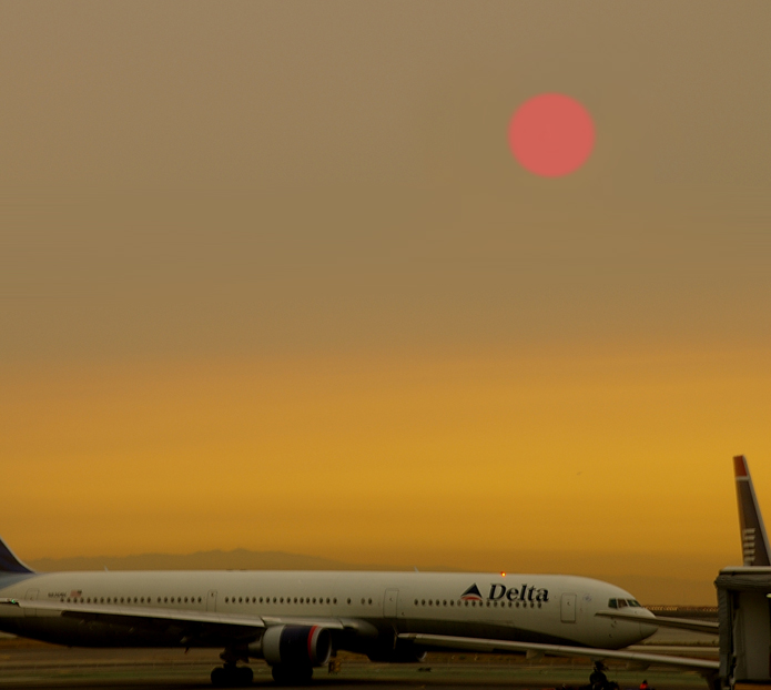 San Francisco, CA: SMOKE FROM NEARBY FIRES turns the morning sun red over San Francisco International Airport in September 2007.