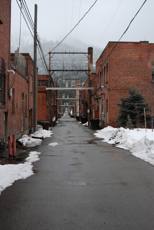 Wallace, ID: an alley of brick buildings in early spring in Wallace