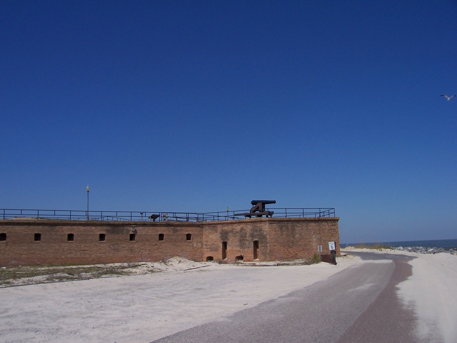Dauphin Island, AL: A cannon on Fort Gaines guards the mouth of Mobile Bay. Note the seagull on the right edge of the image. Bienville Boulevard curves around the base of the fort.