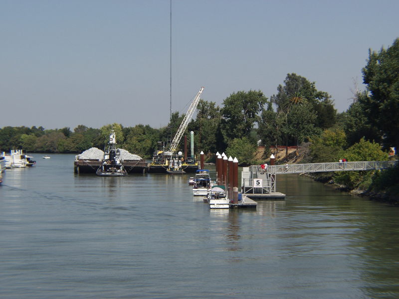 Walnut Grove, CA: View of Walnut Grove public dock with gravel barge and radio tower in background