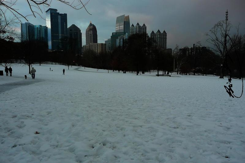 Atlanta, GA: Piedmont Park covered in Snow, with the Midtown Skyline towering over it.