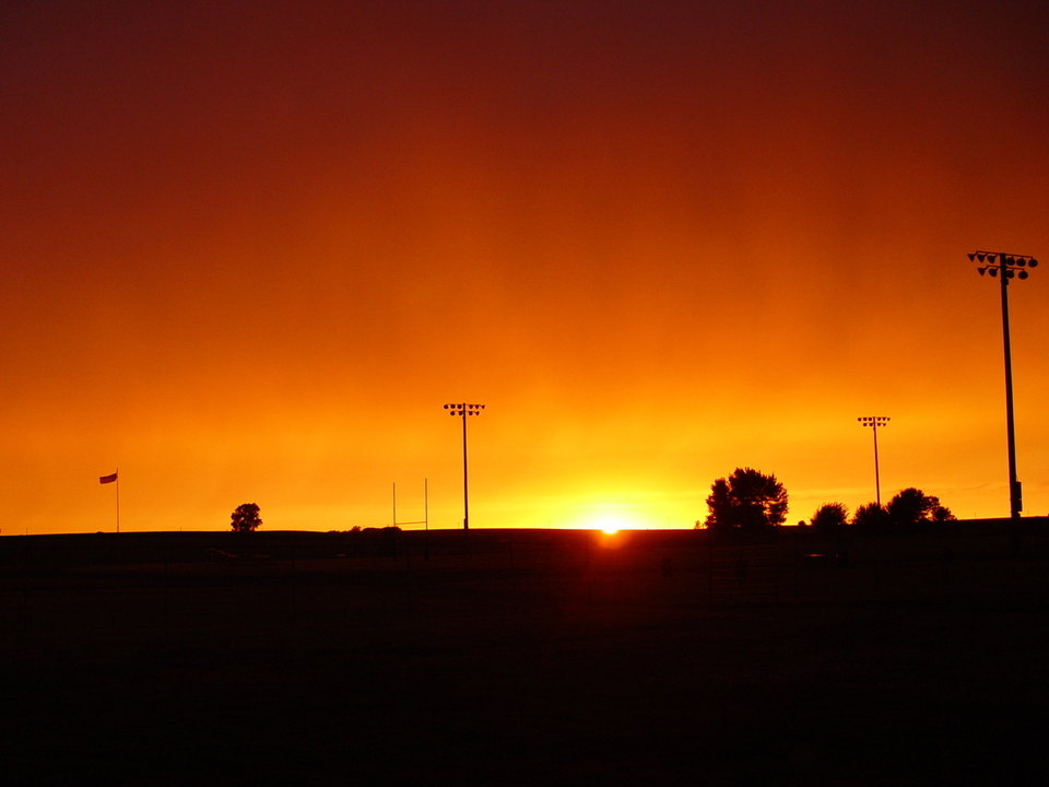 Paullina, IA: August sunset behind high school football field.