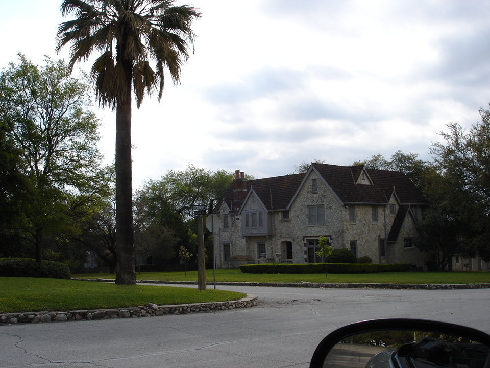 Olmos Park, TX: English/French home with palm tree in Olmos Park, Texas.