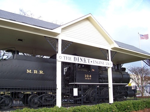 Conyers, GA: A shot of the "Dinky" Engine 104 near "Olde Town" Conyers, Georgia. It is a little bit smaller than the usual steam locomotive, and weighs "only" 94 tons. It is 50 feet long including the tender, and has a 0-6-0 wheel configuration. Built in 1905 by the Rogers company, it spent 1948-1960 doing the short 3 mile run between the Callaway Mill and Conyers.